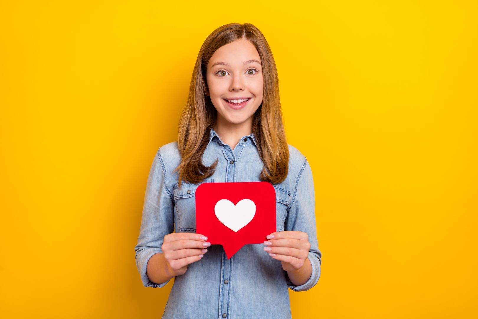 A woman holding a heart icon